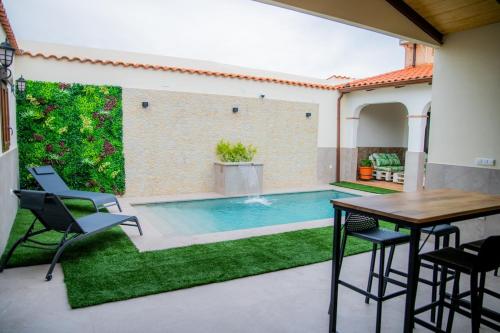 een terras met een tafel en stoelen en een zwembad bij Casa Rural La Bodega de Cortés in Villagonzalo