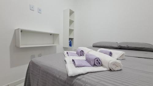 a bedroom with two beds with purple and white towels at Casa 66 Completa Garagem 2ACs WIFI Juazeiro, Crato e Barbalha in Barbalha