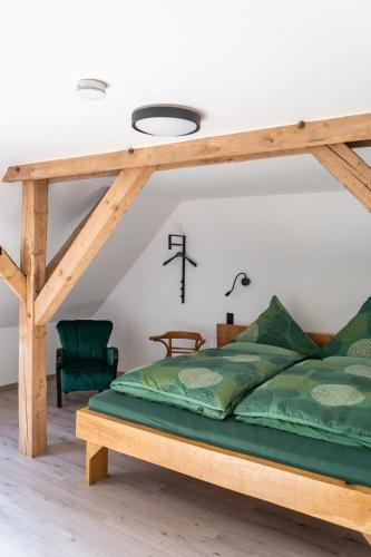 a bedroom with a wooden bed with green sheets at Kiefer -Ferienwohnung in Dötlingen mit Waldblick in Dötlingen