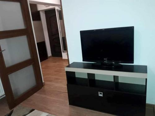 a flat screen tv sitting on top of a dresser at Apartament Decebal- 2 dormitoare in Bistriţa