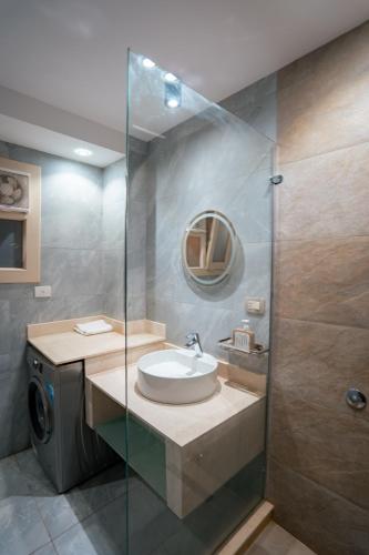 a bathroom with a sink and a glass shower at Luxury Accommodation in Sheikh Zayed