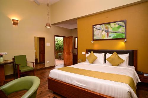 a bedroom with a bed and a desk and a chair at Arara Mhas Hotel in Cherrapunji