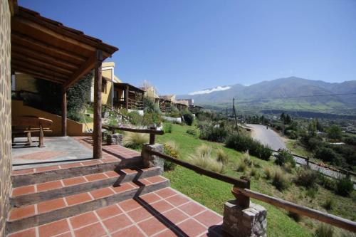 a stone staircase to a house with a view of a mountain at Cabañas Balcones de Tafi in Tafí del Valle