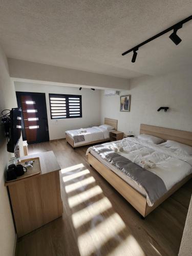 a bedroom with two beds and a large window at Alexander The Great ATG in Skopje