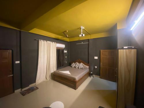 a small bedroom with a bed and a dresser at Haven Stay in Dibrugarh