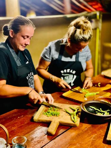 two women in a kitchen preparing food on a cutting board at Dreamville Hostel in Ella
