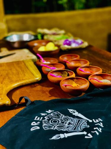 a wooden table with bowls of food on it at Dreamville Hostel in Ella