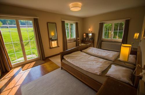 une chambre avec un lit et deux fenêtres dans l'établissement Large Home in Country near Zurich, à Othmarsingen
