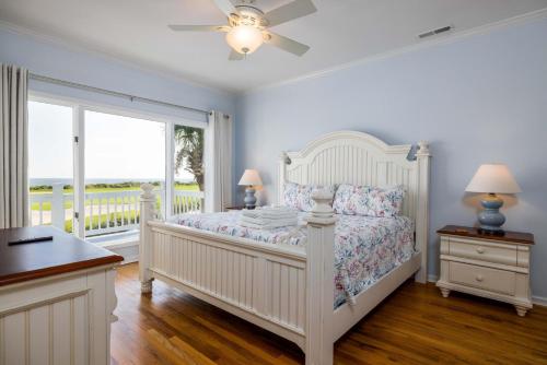 een witte slaapkamer met een bed en een raam bij 325 Ocean Point in Fripp Island