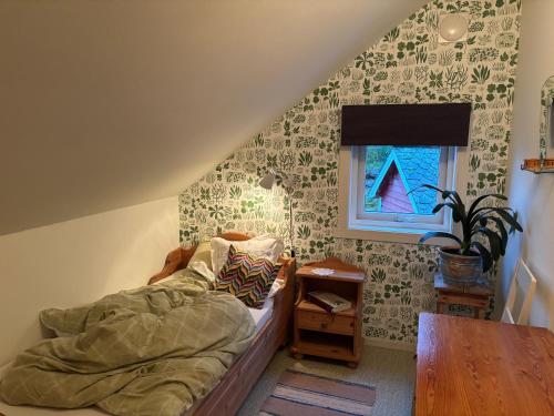 Un dormitorio con una cama y una mesa y una ventana. en Jåstad Gjestetun, en Jåstad