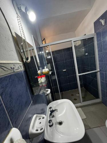 a bathroom with a white sink and a shower at Cabañas Balcones de Tafi in Tafí del Valle