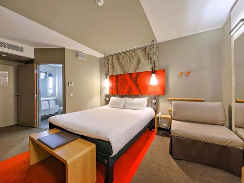 a hotel room with a bed and a chair at Ibis Gdansk Stare Miasto in Gdańsk
