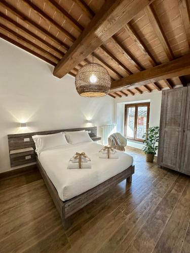 a bedroom with a large bed and a chandelier at Under The Tuscan Sun in Arezzo