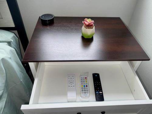 a table with a remote control and a flower on it at Modern Farmhouse Retreat in Urbandale in Urbandale