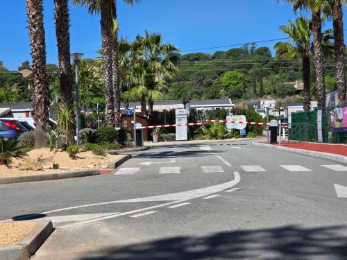 an empty street with palm trees on the side of the road at le plein de bonheur in Fréjus