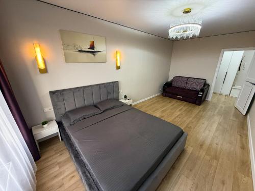 1 комнатная квартира в центре города на Победы 70 في كوستاناي: غرفة نوم بها سرير كبير وأريكة