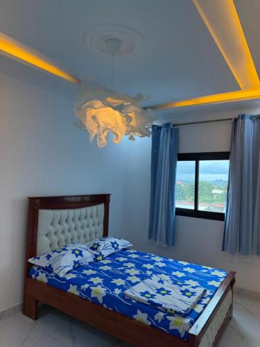 Un dormitorio con una cama con techo azul. en Aloha Suites Odza - by Skyline Residence Services, en Yaoundé