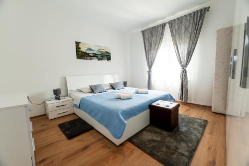 een witte slaapkamer met een bed en een raam bij Villa Bistre in Radovin