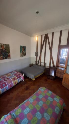 a room with two beds and a window at Casa Atahualpa in Valparaíso