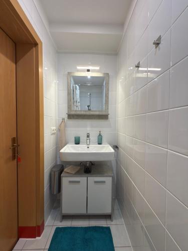 a white bathroom with a sink and a mirror at Traunapartment Altaussee in Altaussee