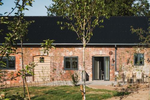 ein Backsteinhaus mit einem schwarzen Dach in der Unterkunft Ridgeway in Marlborough