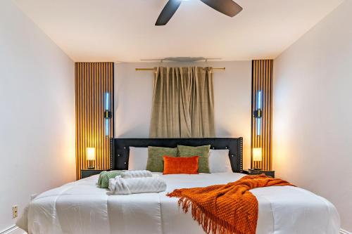 Christmas special, Cozy Luxe Escape, Raleigh 2BR Getaway, Sleeps 4, Pets, Kids & Business Travelers Welcome, Holiday deal في رالي: غرفة نوم مع سرير مع بطانية برتقالية عليه