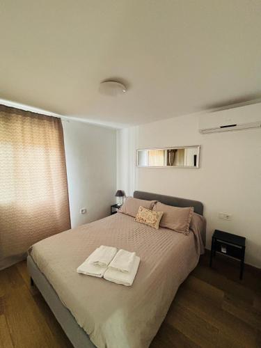 a bedroom with a bed with two towels on it at Libertad A in Santiponce