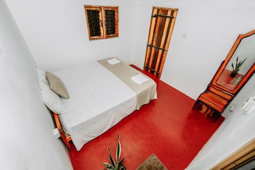 une petite chambre avec un lit et un miroir dans l'établissement Little Cabanas Udawalawe, à Uda Walawe