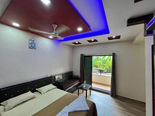 ein Schlafzimmer mit einem Bett und einer blauen Decke in der Unterkunft Coral Beach Resort, Diveagar in Diveagar