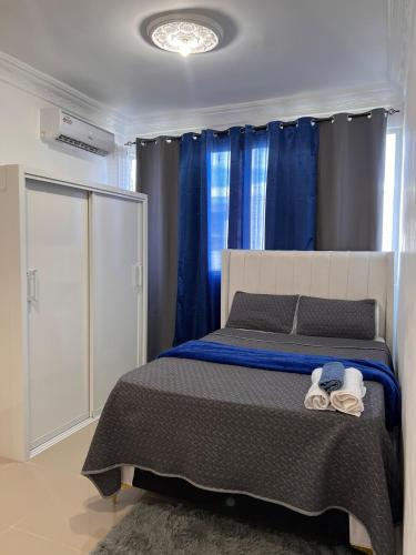 Un dormitorio con una cama grande con cortinas azules. en Luxury Royalty-1, en Santa Cruz de Barahona