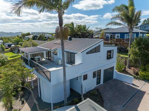 an aerial view of a white house with a palm tree at Topsy Turvey Mangonui Self-Contained Guest Apartment in Mangonui