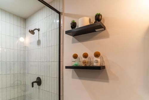 Christmas special, Cozy Luxe Escape, Raleigh 2BR Getaway, Sleeps 4, Pets, Kids & Business Travelers Welcome, Holiday deal في رالي: حمام مع دش ورف مع تماثيل صغيرة