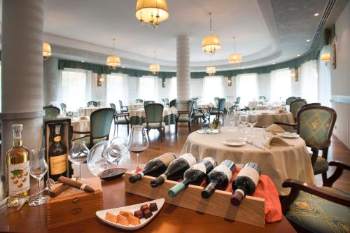 a restaurant with tables with bottles of wine on the floor at Hotel Cavalieri in Bra