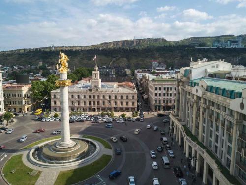 a city with a statue in the middle of a street at ibis Styles Tbilisi Center in Tbilisi City