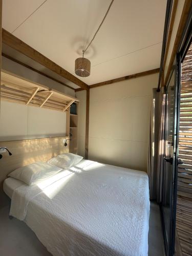 ein Schlafzimmer mit einem großen Bett mit weißer Bettwäsche in der Unterkunft Bungalow vue mer panoramique in Saint-Raphaël