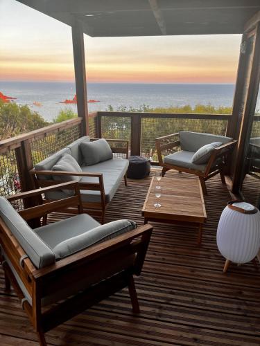 eine Veranda mit Sofas und Meerblick in der Unterkunft Bungalow vue mer panoramique in Saint-Raphaël