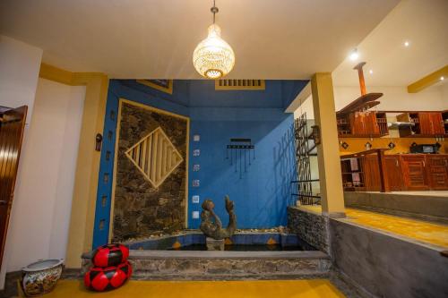 a living room with a blue wall and a pendant light at Mountvilla Exquisite 4-Bedroom Luxury Retreat with Private Pool in Galle