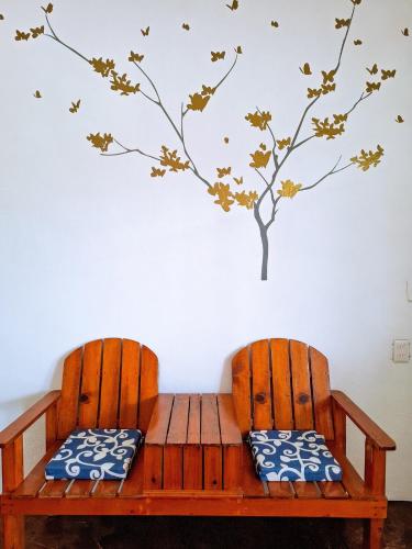 two chairs with a bench with a tree on the wall at Casa Jedidian in El Cuyo
