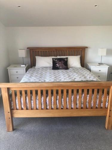 a bedroom with a wooden bed with two night stands at Ruby Bay Loft Accommodation in Nelson