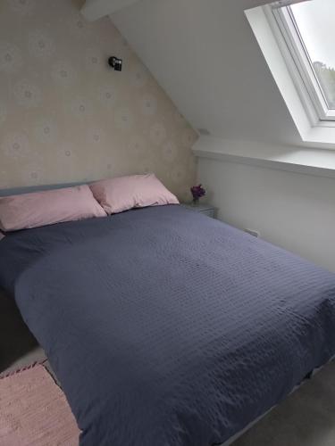 a bedroom with a bed with pink pillows and a window at Views for miles in Monmouth