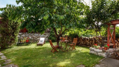 a backyard with a table and chairs and a tree at Penzion Barborka in Poprad