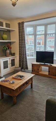 a living room with a coffee table and a flat screen tv at The Park Inn in Stockton-on-Tees