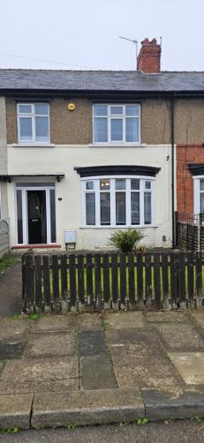 a white house with a fence in front of it at The Park Inn in Stockton-on-Tees