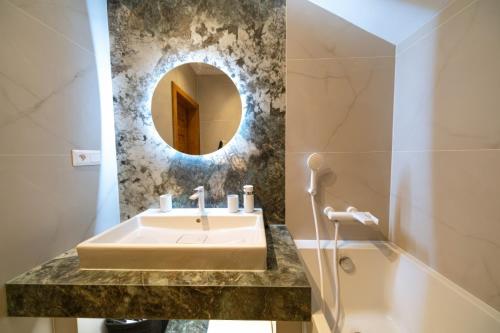 een badkamer met een wastafel en een spiegel bij Villa Merry in Vysoké Tatry