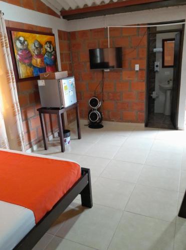 a living room with a couch and a tv at Ecohotel don Salvador in Ulloa