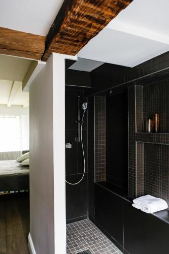 a bathroom with a shower with black walls at L'appartement au-dessus du in Strasbourg