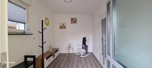 a white living room with a tv and a table at Sunshine in Groß-Zimmern