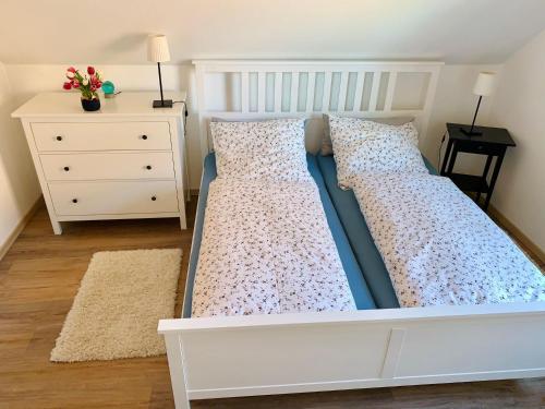 1 cama blanca en un dormitorio con tocador en Ferienwohnung-bei-Familie-Kuehl, en Fehmarn