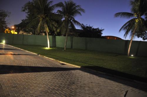 a street with palm trees and a fence at night at Motel UP (Adult Only) in Fortaleza