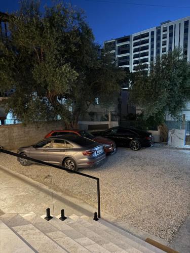 two cars parked in a parking lot next to a building at Casa del Mar in Vlorë